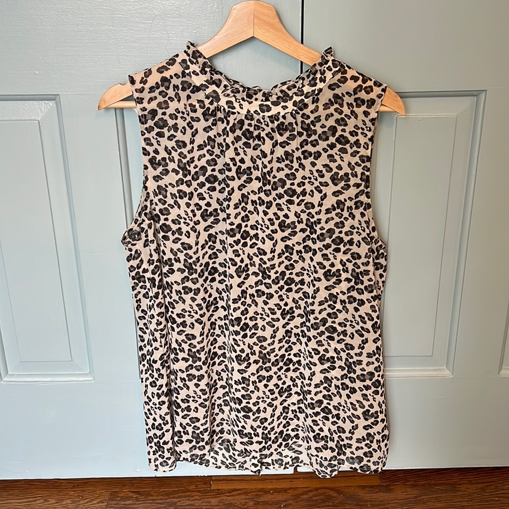 Sleeveless animal print blouse with ruffle detail on the neck